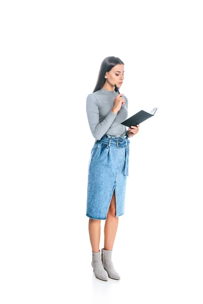 Nachdenkliche junge Frau mit Notizbuch und Stift auf weißem Grund — Stockfoto