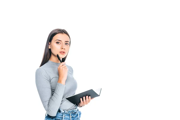 Nachdenkliche junge Frau mit Notizbuch und Stift auf weißem Grund — Stockfoto