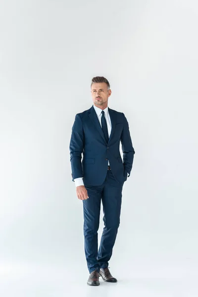 Hombre de negocios guapo en traje azul de pie y mirando hacia otro lado aislado en blanco — Stock Photo