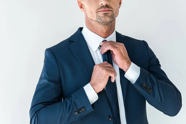Imagem cortada de empresário amarrando gravata isolada no branco — Fotografia de Stock