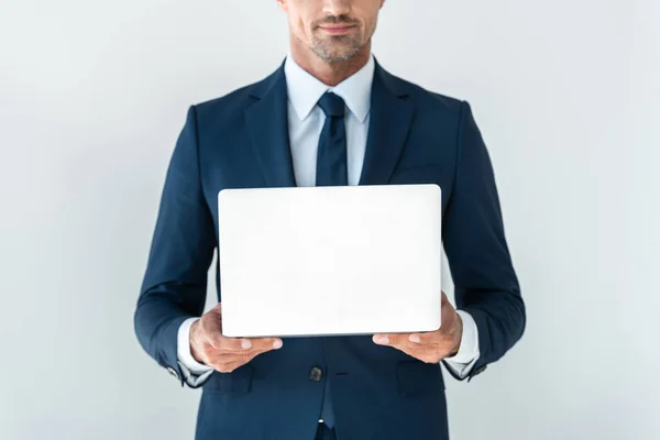 Обрезанное изображение бизнесмена, держащего ноутбук изолированным на белом — стоковое фото