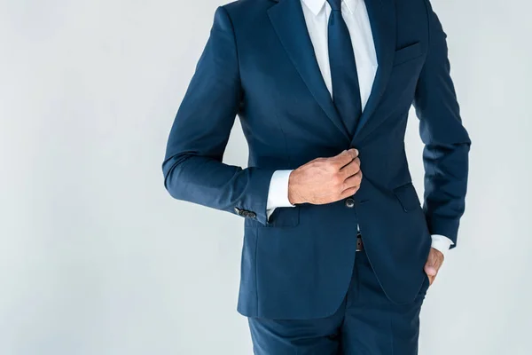 Cropped image of businessman buttoning jacket isolated on white — Stock Photo