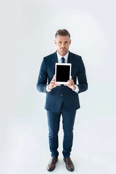 Vista de ángulo alto de hombre de negocios guapo mostrando tableta con pantalla en blanco aislado en blanco - foto de stock