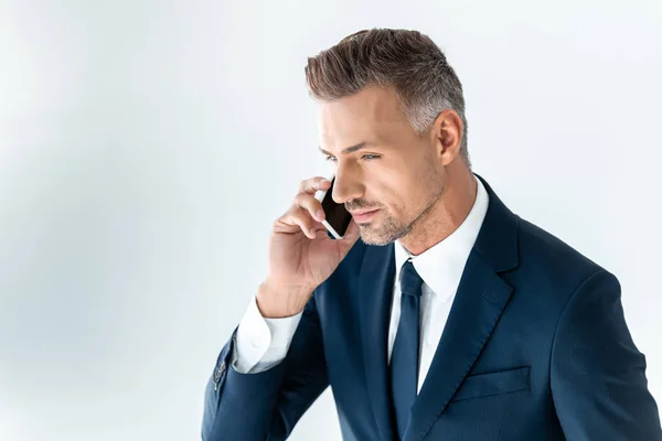 Porträt eines gutaussehenden Geschäftsmannes, der mit dem Smartphone auf Weiß spricht — Stockfoto