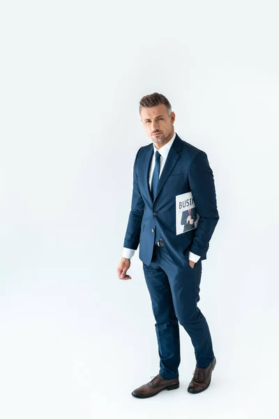 Vue grand angle de bel homme d'affaires debout avec journal et regardant la caméra isolée sur blanc — Photo de stock