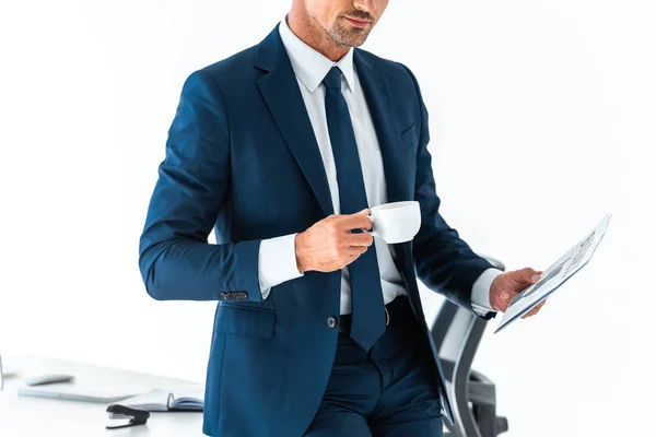 Cropped image of businessman holding cup of coffee and newspaper isolated on white — Stock Photo