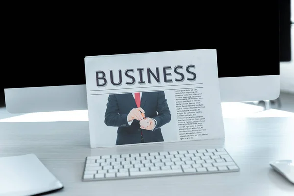 Business newspaper and computer on table in office — Stock Photo