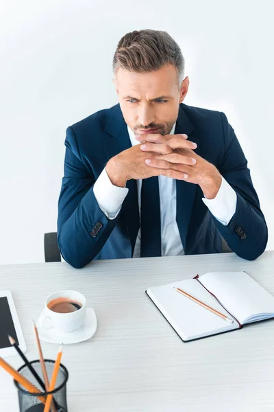 Vista ad alto angolo di bell'uomo d'affari seduto a tavola con caffè e notebook isolato su bianco — Foto stock