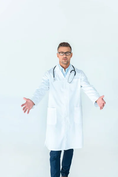 Bel dottore in occhiali in piedi a braccia aperte isolato su bianco — Foto stock