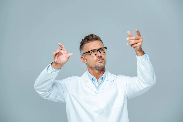 Guapo científico en bata blanca y gafas moviendo algo en el aire aislado en blanco, concepto de inteligencia artificial - foto de stock