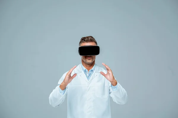 Scientist in virtual reality headset holding something isolated on grey, artificial intelligence concept — Stock Photo