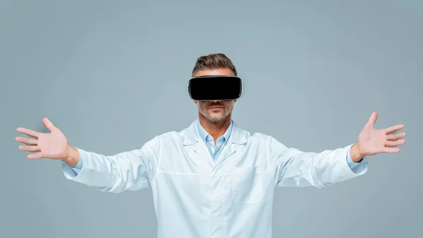 Scientist in virtual reality headset holding something in air isolated on grey, artificial intelligence concept — Stock Photo
