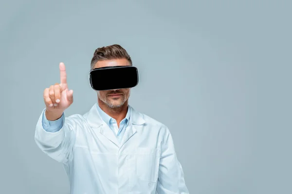 Вчений у гарнітурі віртуальної реальності торкається чогось пальцем ізольованого на сірій концепції штучного інтелекту — стокове фото