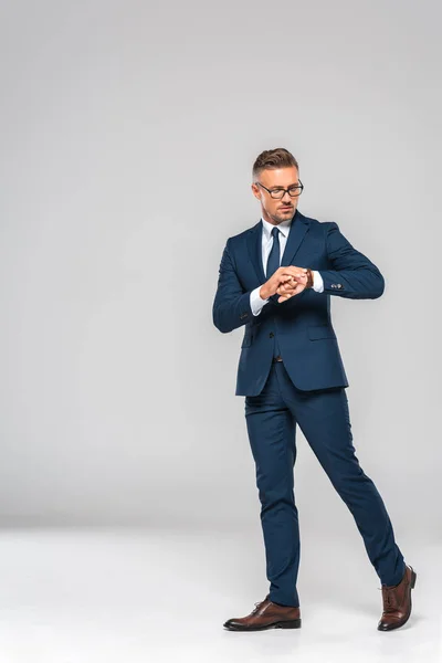 Guapo hombre de negocios comprobar el tiempo en reloj de pulsera aislado en blanco - foto de stock