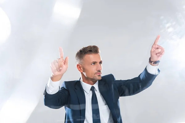 Apuesto hombre de negocios moviendo algo aislado en blanco, concepto de inteligencia artificial - foto de stock