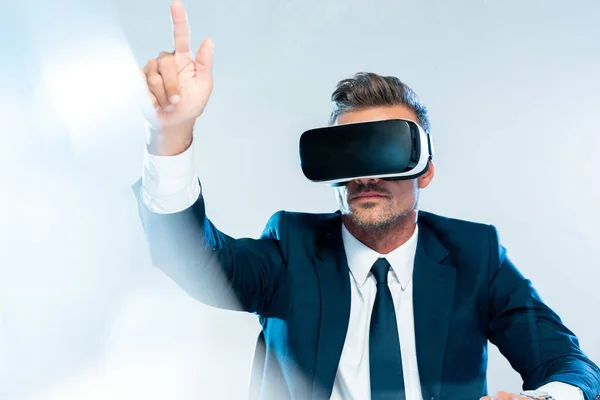 Uomo d'affari in realtà virtuale auricolare toccare qualcosa di isolato su bianco, concetto di intelligenza artificiale — Foto stock