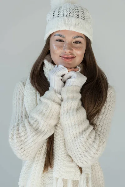 Donna attraente allegra in maglione invernale alla moda e sciarpa guardando la macchina fotografica isolata su bianco — Foto stock