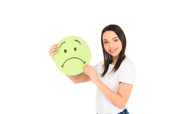 Attractive woman holding green sign with sad face expression while smiling at camera isolated on white — Stock Photo