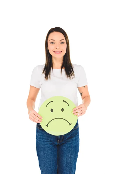 Menina atraente segurando sinal verde com expressão facial triste enquanto olha para a câmera isolada no branco — Fotografia de Stock