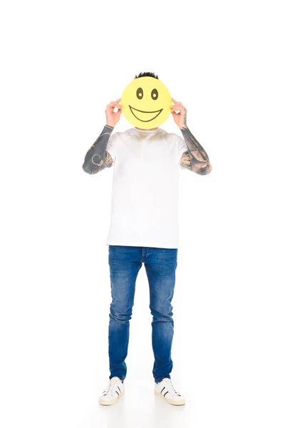 Homme avec tatouages tenant signe jaune avec expression joyeuse du visage isolé sur blanc — Photo de stock