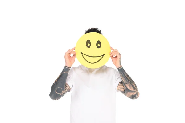 Man with tattoos holding card with smiling face expression isolated on white — Stock Photo