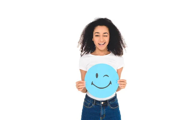 African american girl holding sign with winking face expression isolated on white — Stock Photo