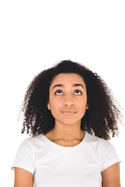 Красива афроамериканська дівчина в білій футболці дивиться вгору ізольовано на білому — стокове фото