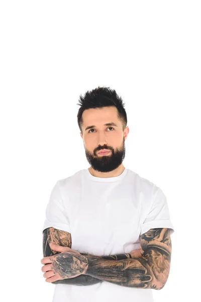 Hombre barbudo en camiseta blanca con tatuajes mirando hacia arriba aislado en blanco - foto de stock