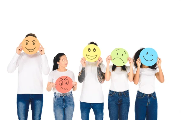 Amigos multiculturales escondiendo caras detrás de carteles de colores aislados en blanco - foto de stock