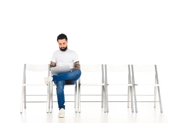 Hombre barbudo guapo usando portátil aislado en blanco - foto de stock