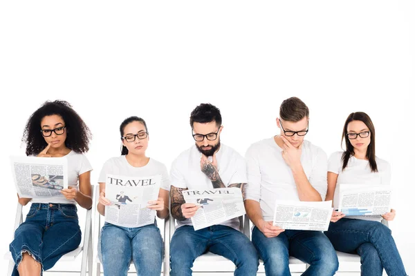 Multiethnische Gruppe junger Menschen in Brillen, die Zeitungen lesen, isoliert auf weißem Grund — Stockfoto