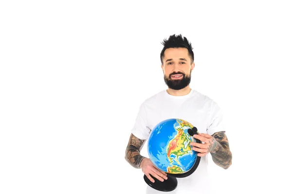 Smiling bearded tattooed man holding globe isolated on white — Stock Photo