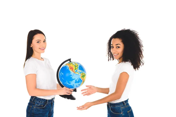 Smiling woman giving globe to african american girl  isolated on white — Stock Photo