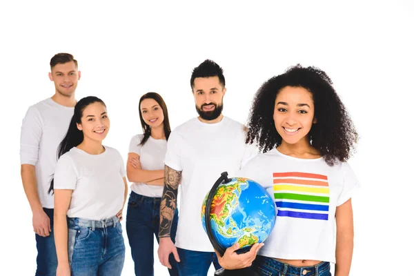 Multiethnische Gruppe junger Menschen hinter afrikanisch-amerikanischer Frau mit lgbt Zeichen auf T-Shirt hält Globus isoliert auf weiß — Stockfoto