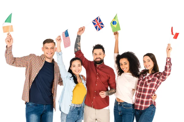 Багатонаціональна група людей, посміхаючись з прапорами різних країн над головами ізольовані на білому — стокове фото