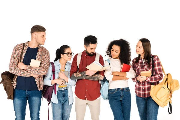 Grupo multicultural de personas mirando el libro en manos de un hombre guapo aislado en blanco - foto de stock