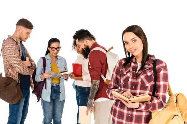 Attractive girl holding book near group of young people isolated on white — Stock Photo