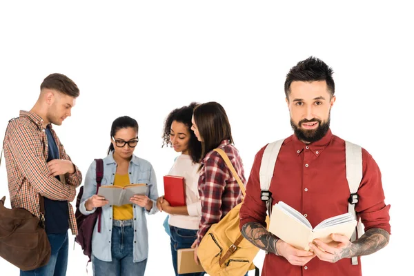 Handsome man holding book near group of young people isolated on white — Stock Photo
