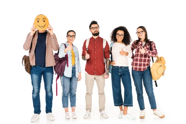 Milticultural group of people in glasses showing thumbs up and standing with man showing happy emotion on card isolated on white — Stock Photo