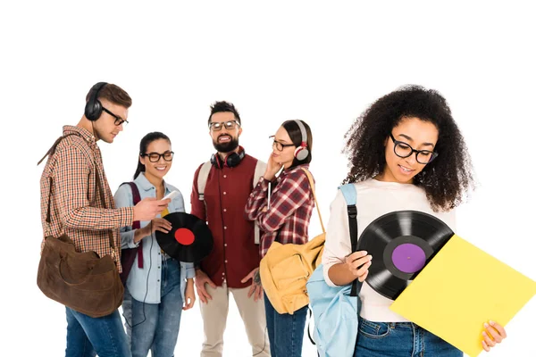 Beautiful african american girl standing with vinyl record near milticultural group of people in glasses isolated on white — Stock Photo