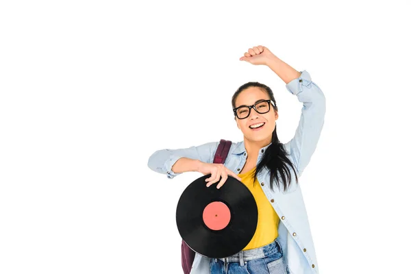 Chica feliz en vasos sosteniendo disco de vinilo con la mano por encima de la cabeza aislado en blanco - foto de stock