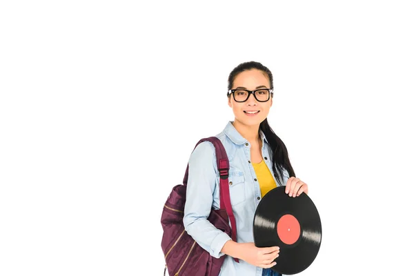 Smiling woman standing with backpack and holding vinyl record in hands isolated on white — Stock Photo