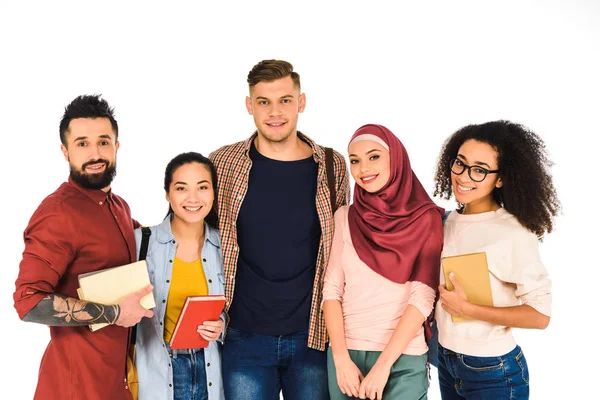 Gruppo multietnico di giovani in piedi con libri isolati su bianco — Foto stock