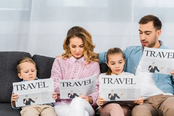 Семья сидит на диване и читает туристические газеты в квартире — стоковое фото