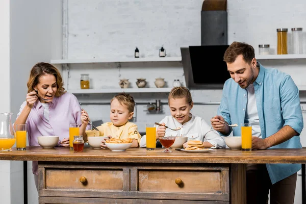 Glückliche Familie isst Brei am Tisch in der Küche — Stockfoto