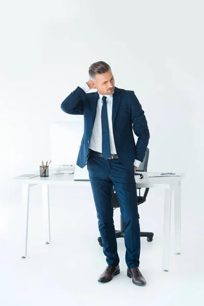 Schöner Geschäftsmann berührt Hinterkopf isoliert auf weiß — Stockfoto