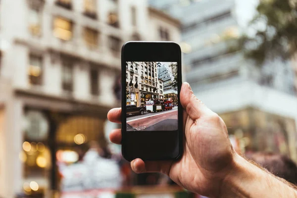 Обрезанный мужчина со смартфоном фотографирует улицу Нью-Йорка — стоковое фото