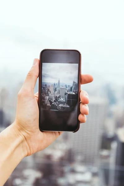 Recortado tiro fo hombre con teléfono inteligente tomar una foto de la ciudad de Nueva York - foto de stock
