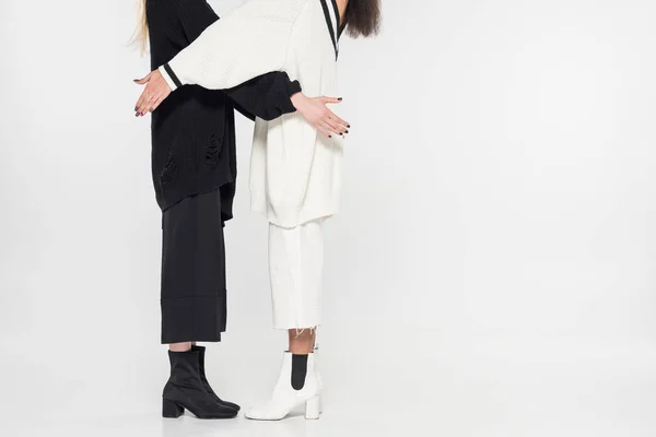 Cropped image of multicultural women in black and white clothes standing on white — Stock Photo