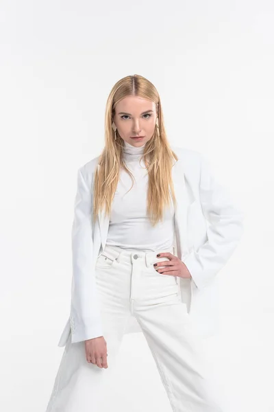 Attractive caucasian blonde woman in fashionable white clothes standing, posing and looking at camera isolated on white — Stock Photo